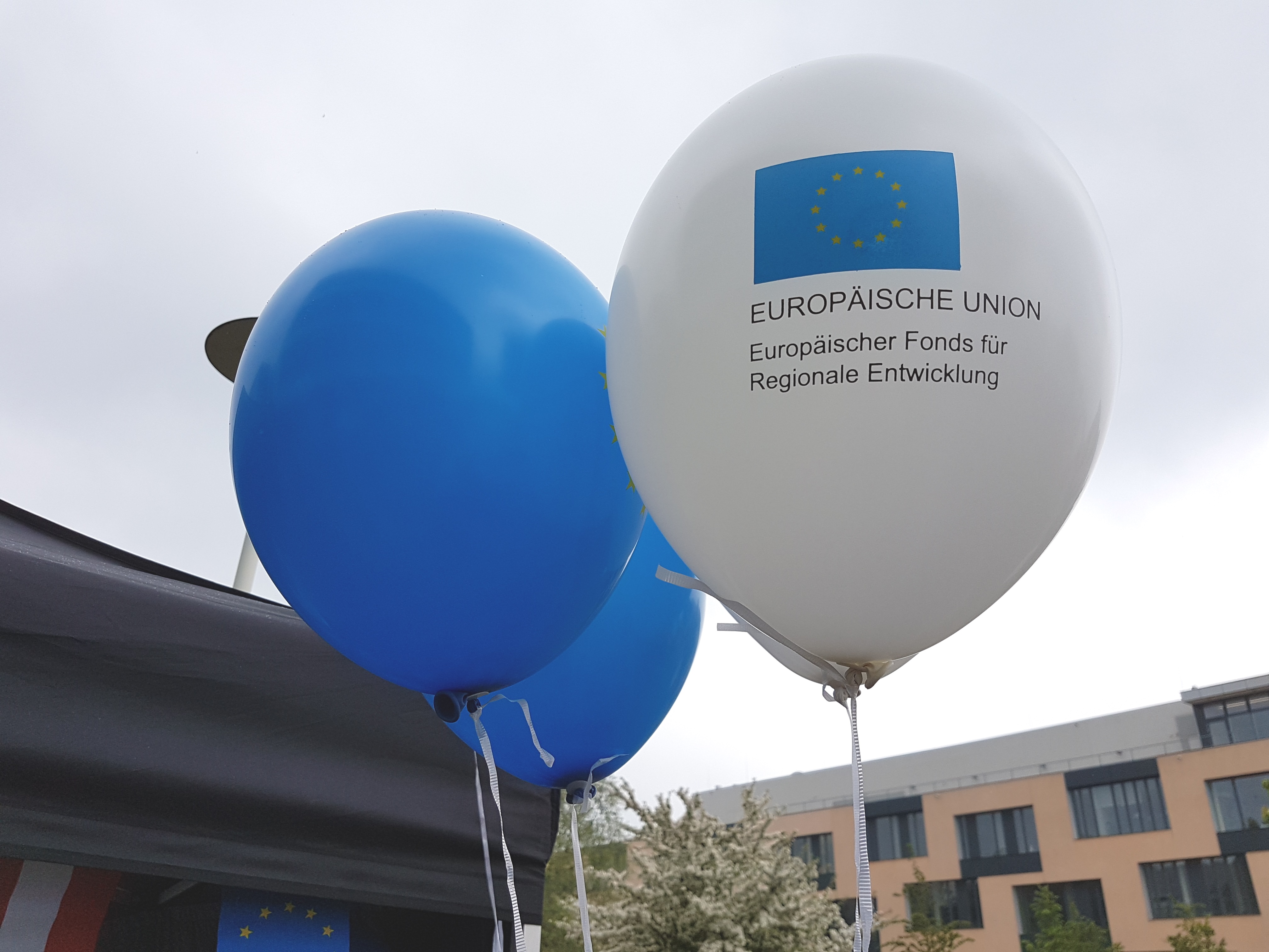 Weiße und blaue Luftballons mit EFRE-Logo
