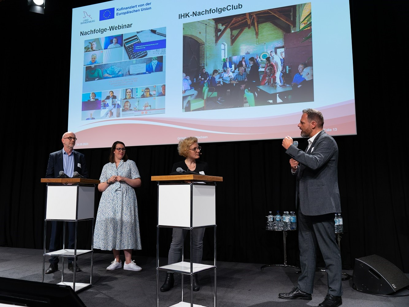 Bild: Auf der Bühne stehen die Moderatorin, ein Vertreter der ILB und der IHK Potsdam sowie eine Unternehmerin.
