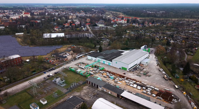 Luftaufnahme der großen Hallen der MATTIG & LINDNER GmbH mit Solaranlagen und Wohnhäusern im Hintergrund