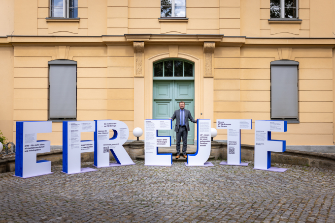 Abbildung des Ministers Daniel Keller neben den EFRE- und JTF-Buchstaben zur Info-Tour