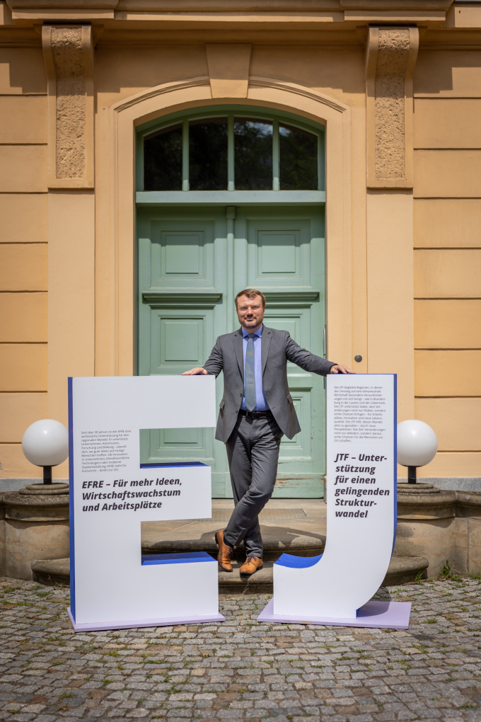 Darstellung des Ministers Daniel Keller neben E und J für EFRE und JTF zum Start der Info-Tour