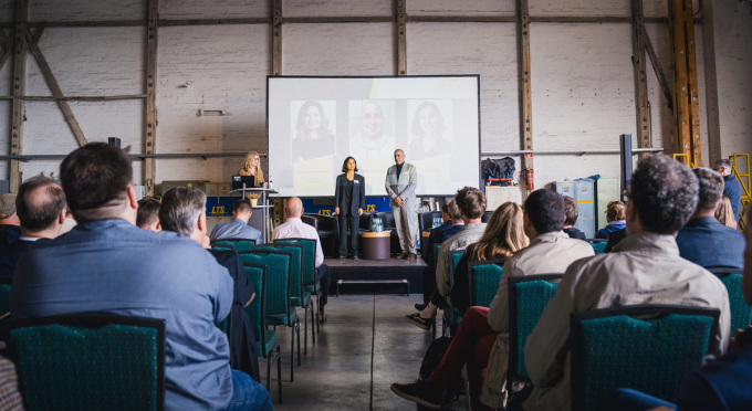 Blick in den Veranstaltungsraum mit Publikum und Podium